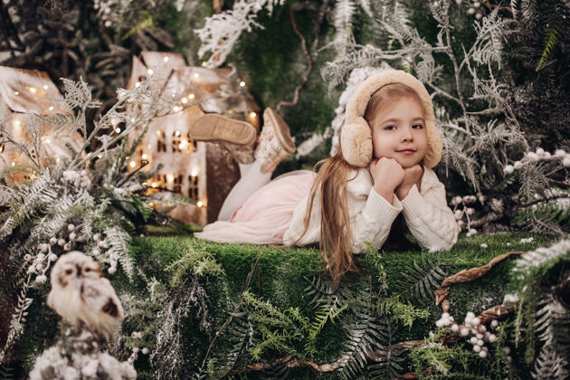 孩子漂亮的白种人小孩 长着金色的长发 躺在圣诞气氛中 周围有很多装饰树孩子年装饰