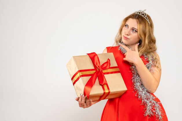 红色正面图身着红色连衣裙的年轻女性手持圣诞礼物人丝带圣诞节