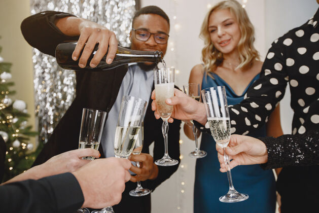 除夕夜一群年轻人庆祝新年朋友们喝香槟成人节日团体