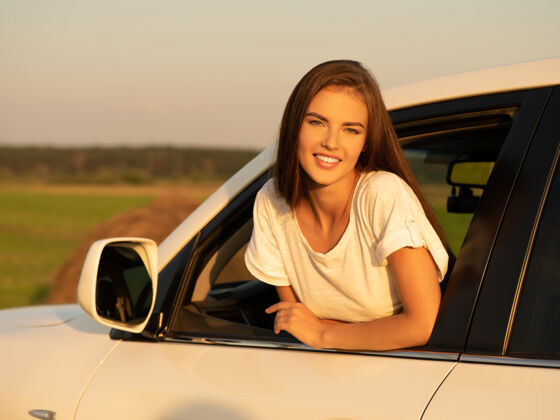 白种人在车里微笑着看着窗外的女人微笑驾驶车辆