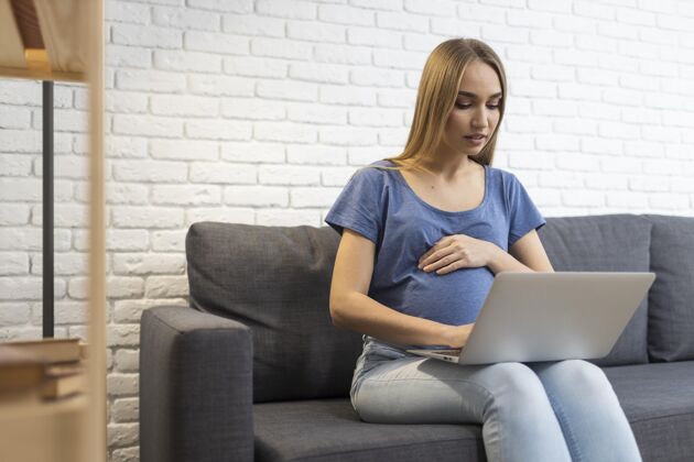 职业坐在沙发上用笔记本电脑工作的孕妇妈妈怀孕职业