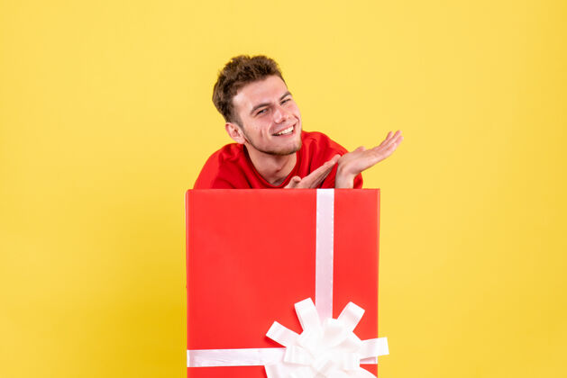 年正面图穿红衬衫的年轻男子站在礼品盒内礼物颜色节日