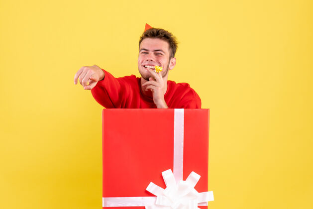 男正面图穿红衬衫的年轻男子坐在礼品盒内雪年轻男情感