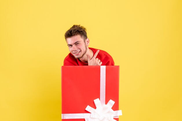 微笑正面图年轻男性站在礼品盒内雪节日圣诞老人