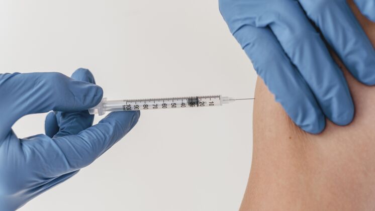 安全戴手套的医生给病人注射疫苗注射器药物水平