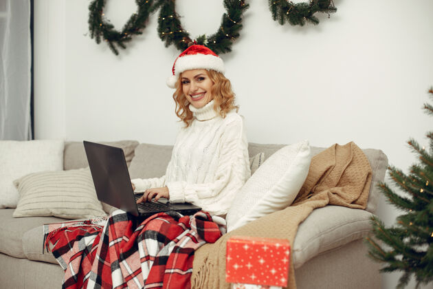 礼物房间里的女人穿白毛衣的金发女人拿着笔记本电脑的女人盒子兴奋化妆品