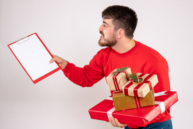 情感身穿红衫的年轻人拿着圣诞礼物在白墙上争吵的正面图抱着圣诞节年轻