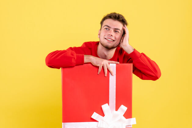 坐着正面图穿红衬衫的年轻男子坐在礼品盒内年情感年轻男性