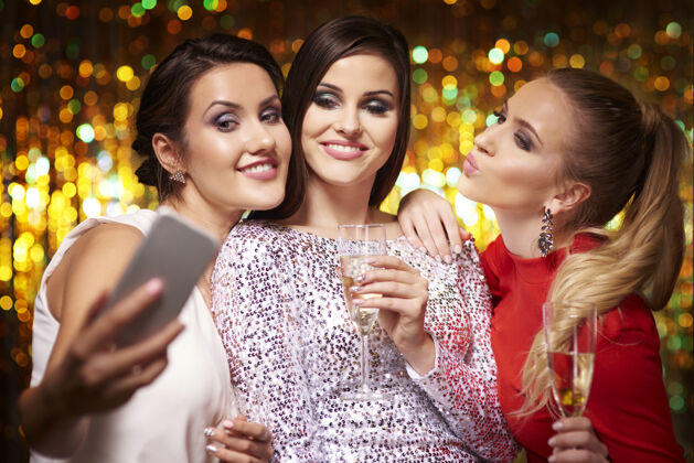 聚会在派对上自拍的女孩们手机酒精正式服装