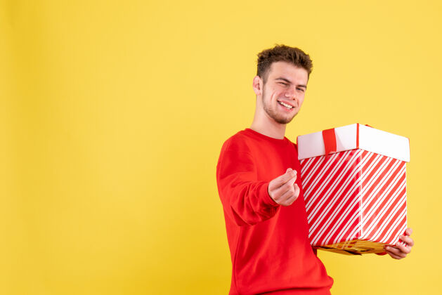 礼物正面图：穿着红色衬衫的年轻男性 带着圣诞礼物人红色男性