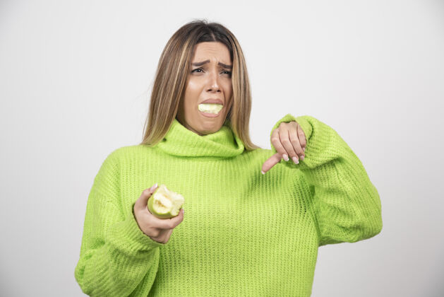 饮食穿着绿色t恤的年轻女子正在吃苹果女性成人表情
