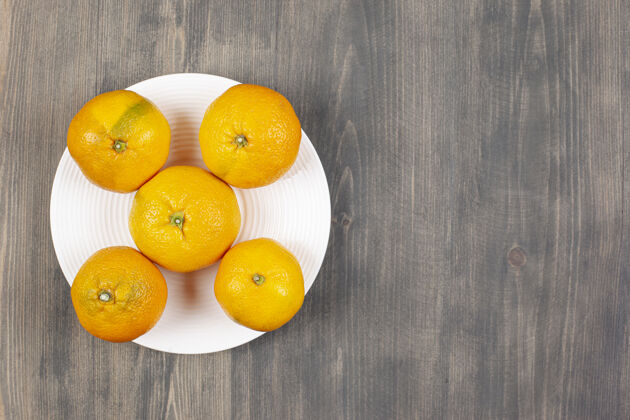 吃一个白色的盘子里装满了甜甜的新鲜橘子高质量的照片橘子多汁美味