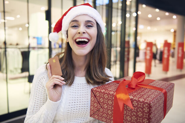 展示在圣诞节购物期间信用卡是非常必要的女人零售休闲活动