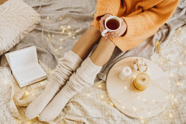 放松高角度的女人用一杯茶享受寒假愉快室内舒适