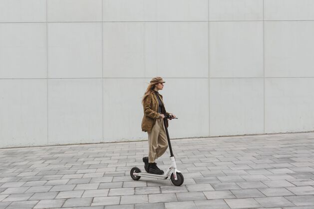 Escooter骑电动车的年轻女子交通年轻女士城市