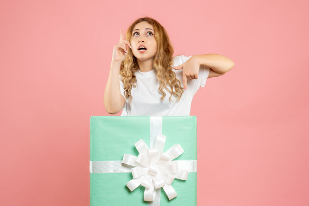 礼物正面图：站在蓝色礼品盒内的年轻女性成人女性丝带
