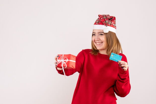 肖像前视图年轻女性 带着小圣诞礼物和银行卡帽子漂亮年轻