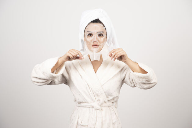 皮肤护理穿着浴衣和带面罩的毛巾的女人水疗浴袍成人