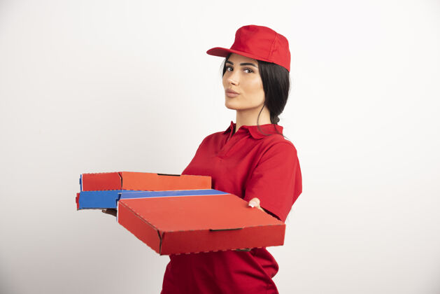 红色年轻的披萨送货员拿着披萨盒女孩红色制服食物