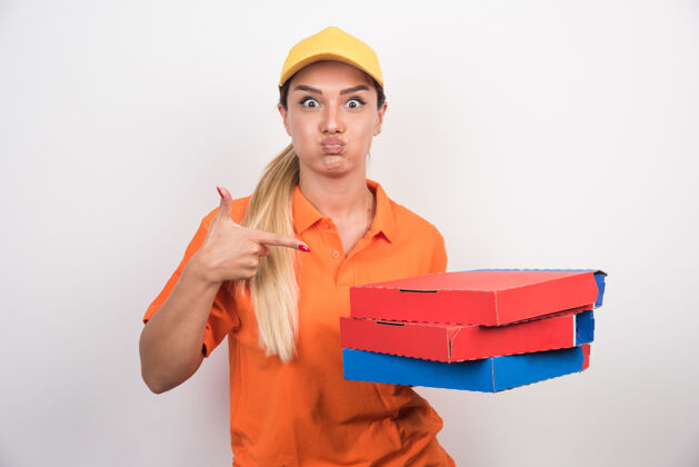 食物送货员戴着黄色帽子指着披萨盒快乐年轻服务