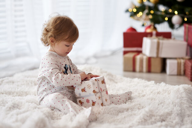 装饰侧视图迷人的婴儿打开圣诞礼物可爱衣服迷人