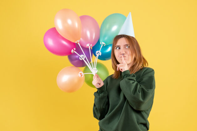 女性正面图：带着彩色气球的年轻女性节日乐趣气球