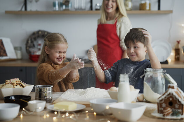 甜食孩子们在为圣诞饼干准备糕点时玩得很开心帮助烘焙准备