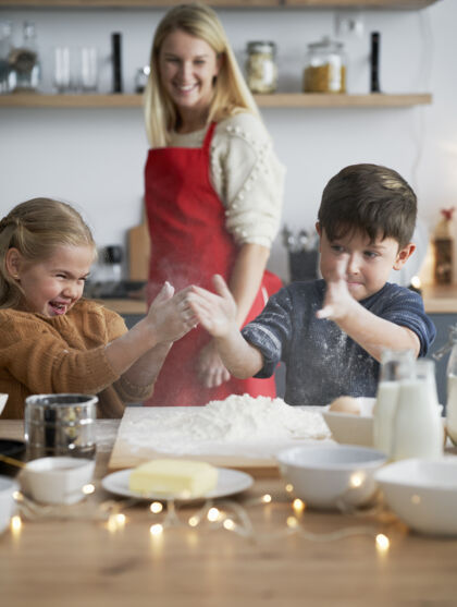欢乐孩子们在烤饼干的时候用面粉紧握的垂直图像肮脏食物装饰