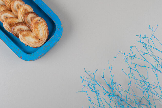 商品在大理石背景上的蓝色盘子里包着薄饼美味的烘焙的商品糖