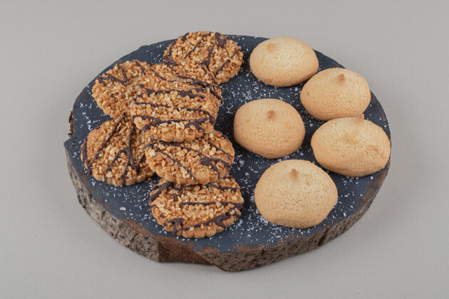 配料各式各样的饼干堆在大理石背景的木板上巧克力烘焙芝麻