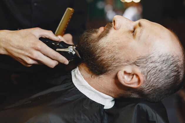 服务有胡子的男人有客户的理发师刮胡子的男人胡子胡须椅子