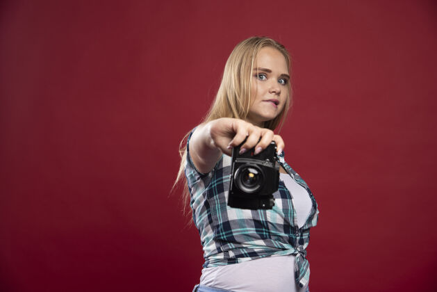 乐趣年轻的金发女郎手持专业相机 在陌生的位置自拍年轻相机女性