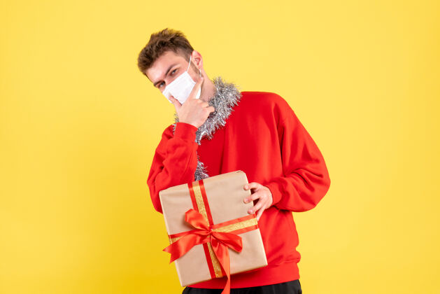 面具正面图：戴着无菌面具的年轻男性正在过圣诞节圣诞节女士颜色