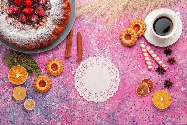 视图俯瞰美味的草莓蛋糕与饼干和一杯茶的粉红色背景蛋糕烤甜甜饼干饼干派派饼干生的