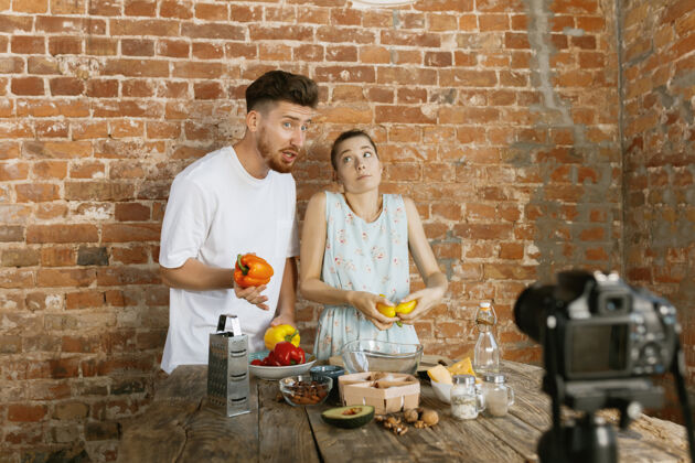 夫妇年轻夫妇烹饪和录制视频直播的虚拟博客和社交媒体厨师拍摄相机