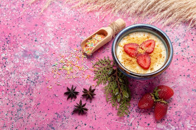 餐俯瞰美味的奶油甜点与淡粉色背景上的红色切片草莓甜点冰淇淋草莓奶油甜水果生的蔬菜午餐