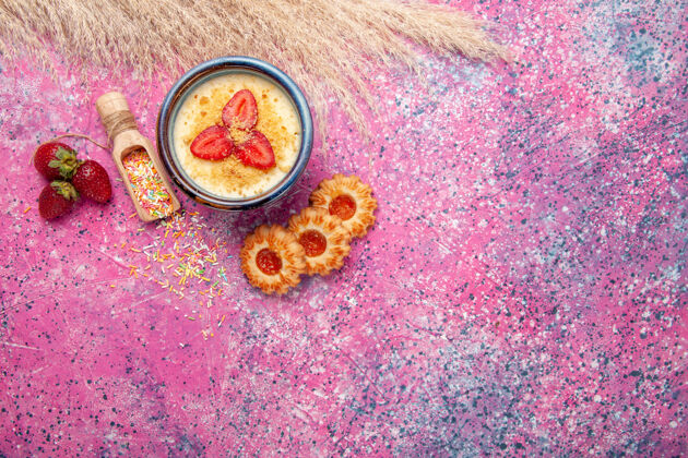 小顶视图美味的奶油甜点与红色切片草莓和小饼干的浅粉色背景甜点冰淇淋浆果奶油甜水果细菌冰淇淋切片