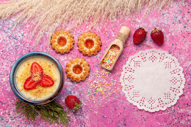 甜点顶视图美味的奶油甜点与红色切片草莓和饼干浅粉色背景甜点冰淇淋甜浆果冰淇淋草莓生的