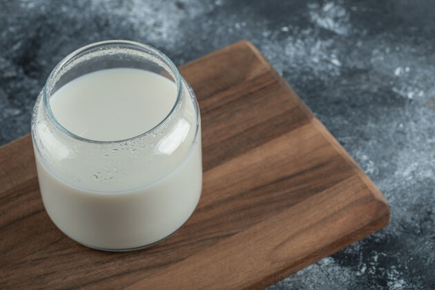 饮料一杯鲜奶放在木板上饮料透明木材