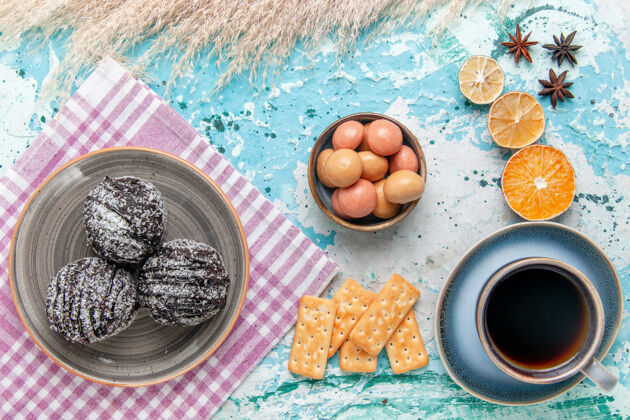 生的俯瞰一杯咖啡 巧克力糖霜蛋糕和薄脆饼干放在浅蓝色的表面蛋糕烘烤甜甜的糖派饼干早餐风景派