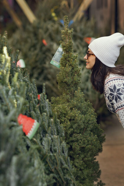 庆祝优雅的女孩买了一棵圣诞树帽子市场传统