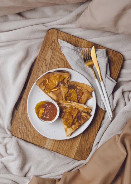 小吃早餐薄饼的俯视图在床上与果酱菜薄饼早午餐