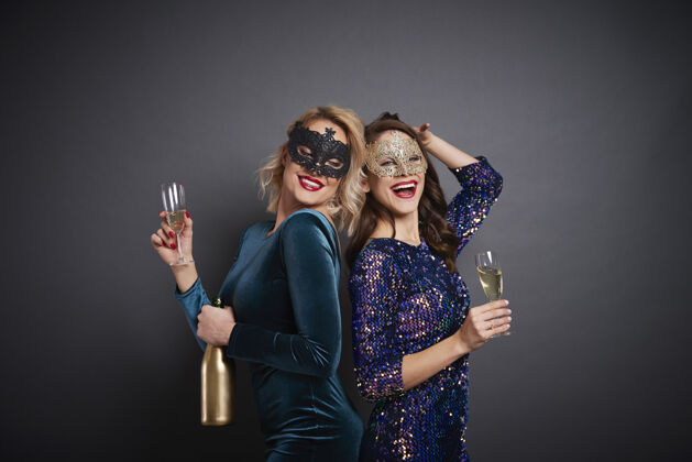 庆典戴面具的女人在摄影棚喝香槟迪斯科舞蹈朋友兴奋
