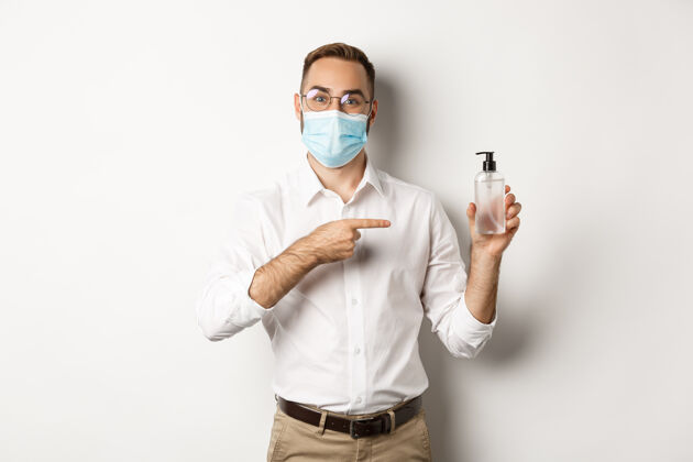 老板戴着医用口罩的上班族指着洗手液 露出抗菌的白色背景企业家衬衫自信