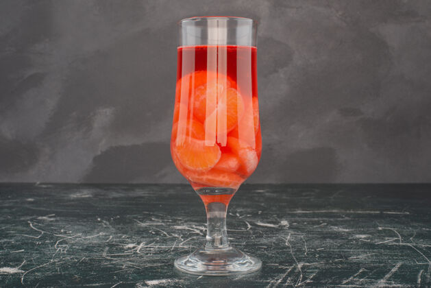 水果大理石桌上放着一杯橘子汁冷美味饮料