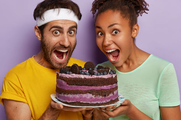 美味摄影棚拍摄的喜极而泣的多民族夫妇手持美味的蓝莓蛋糕个性女性味道