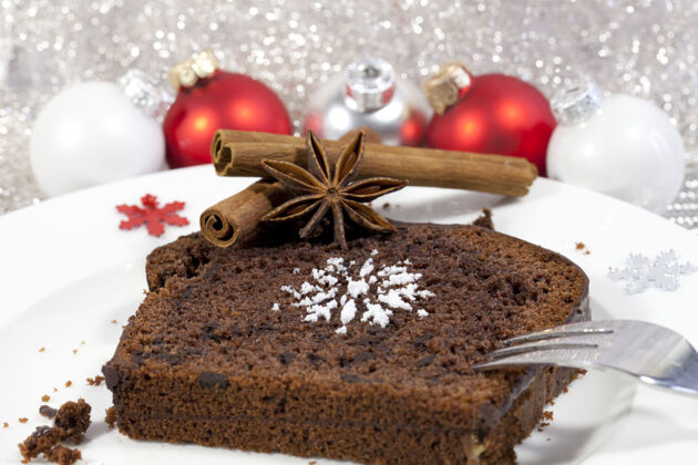 烘焙背景是肉桂和红色圣诞树饰品的布朗尼特写镜头盘子美味休息