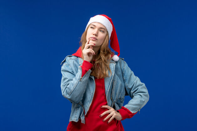 成人正面图：戴着红帽子的年轻女性在蓝色空间思考年前面艺人