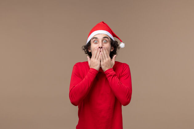 人前视图年轻人与震惊的表情棕色背景圣诞节情感节日脸喜剧演员男人