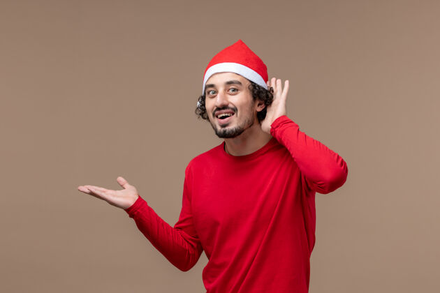 人正面图年轻男性聆听棕色背景情感节日圣诞节聆听表演者帽子